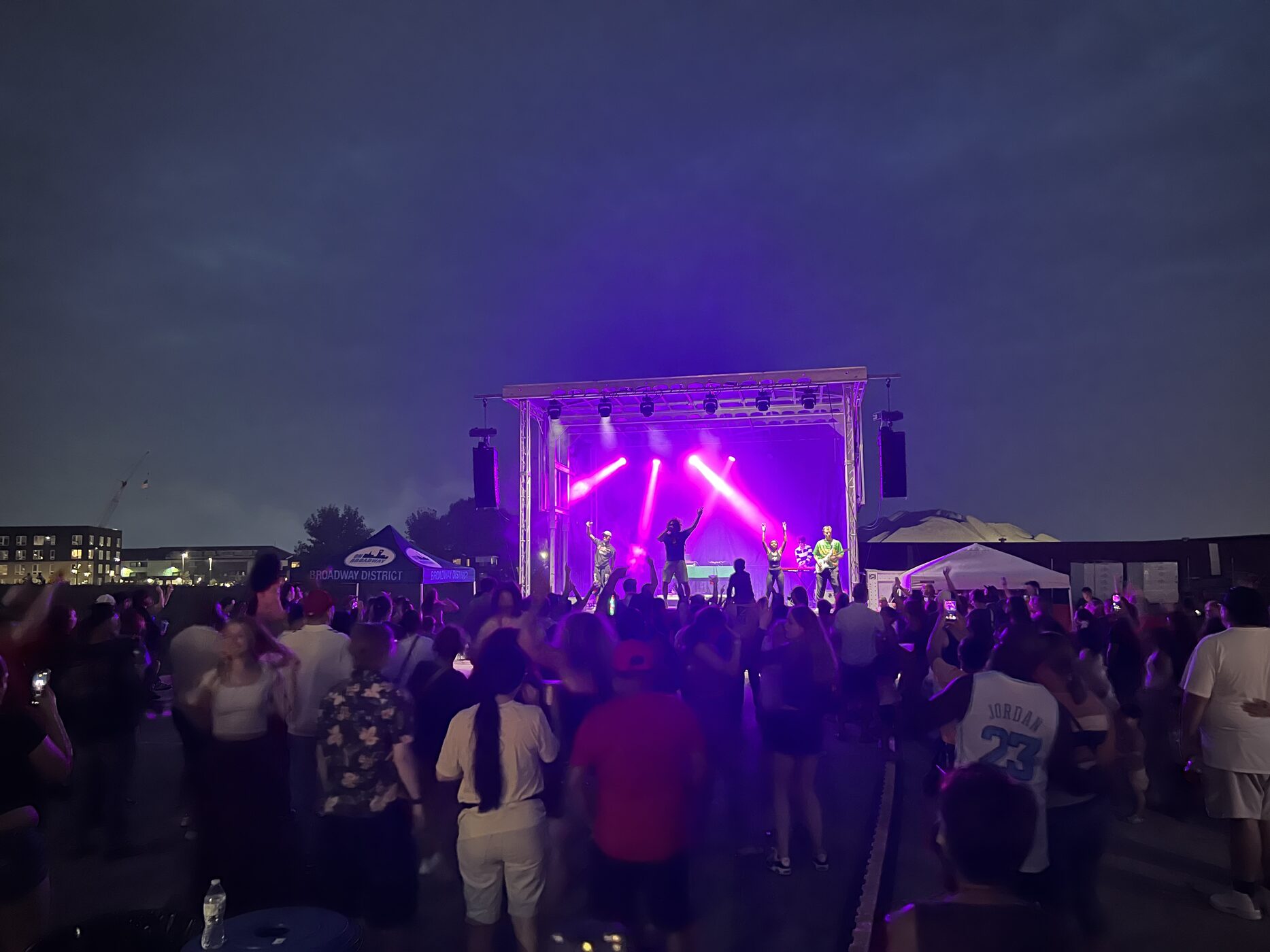 A crowd filling the Broadway District for a Harmonic Productions outdoor concert